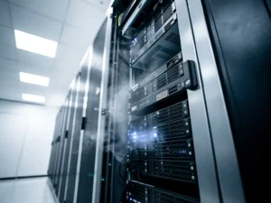 Open server rack in a data center corridor with faint nitrogen gas suppression mist drifting across black hardware under cool overhead lighting.